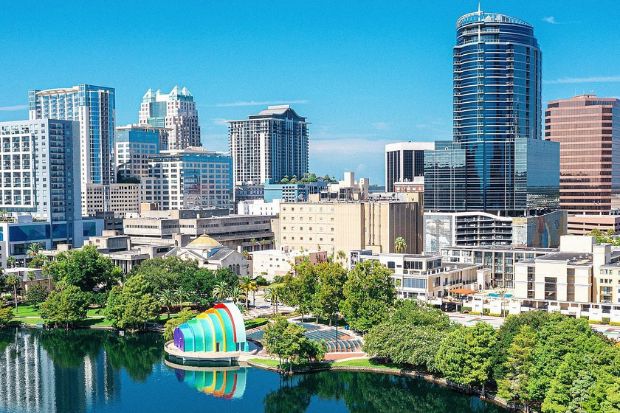 Trung tâm Orlando nhìn từ hồ Lake Eola, nổi bật với nhà hát ngoài trời nhiều màu sắc Trung tâm Orlando nhìn từ hồ Lake Eola, nổi bật với nhà hát ngoài trời nhiều màu sắc