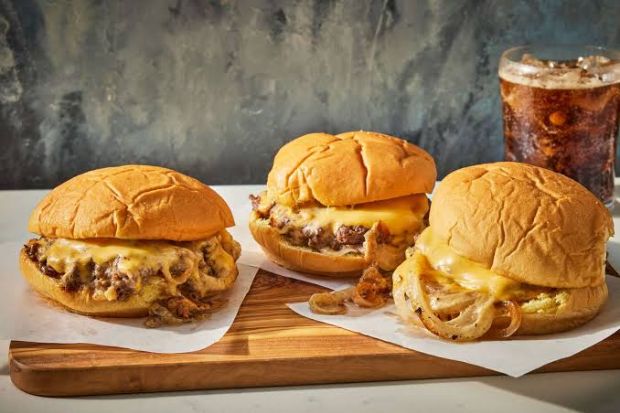 Oklahoma onion burger với b&aacute;nh m&igrave; mềm, ph&ocirc; mai tan chảy v&agrave; h&agrave;nh t&acirc;y th&aacute;i mỏng &aacute;p chảo