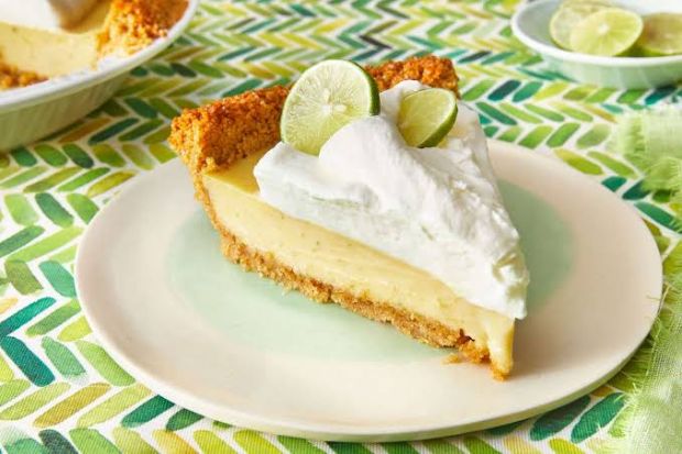 Bánh Key lime pie với đế bánh giòn, lớp kem tươi và lát chanh xanh trang trí Bánh Key lime pie với đế bánh giòn, lớp kem tươi và lát chanh xanh trang trí