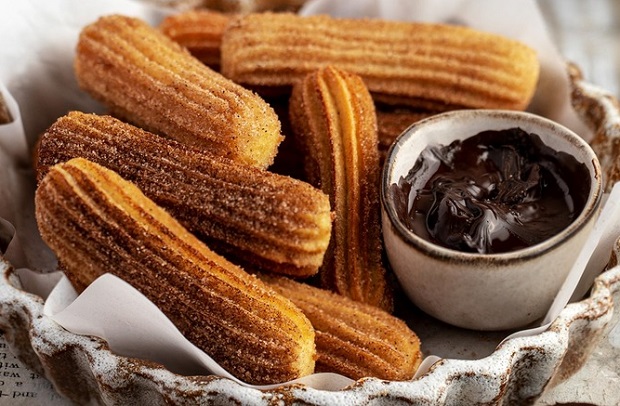 Churros thường được ví như món "bánh quẩy" phiên bản ngọt với sốt socola ngọt ngào  Churros