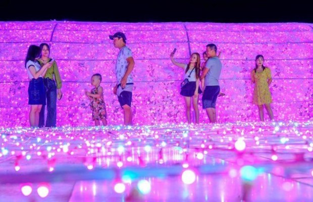 Du kh&aacute;ch chụp ảnh tại lễ hội &aacute;nh s&aacute;ng Đ&agrave; Nẵng với nền đ&egrave;n LED lung linh