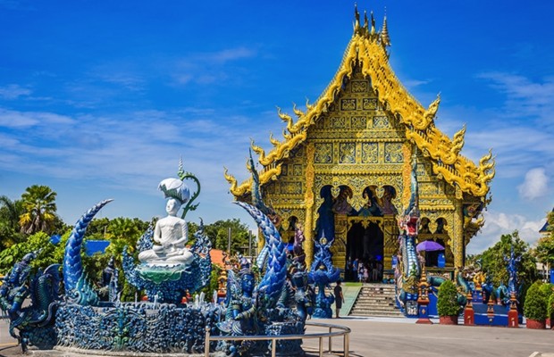 Mặt tiền Ch&ugrave;a Xanh Wat Rong Suea Ten tại Chiang Rai rực rỡ với m&agrave;u xanh dương v&agrave; tượng Phật trắng.