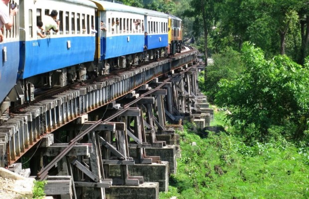 Đo&agrave;n t&agrave;u hỏa đang di chuyển qua đoạn đường ray bằng gỗ cheo leo b&ecirc;n v&aacute;ch n&uacute;i