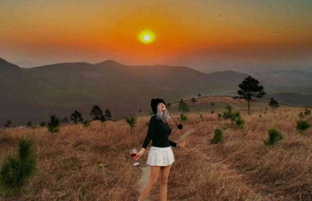 C&ocirc; g&aacute;i ngắm ho&agrave;ng h&ocirc;n rực rỡ tr&ecirc;n thảm cỏ v&agrave;ng B&atilde;i Cỏ Ch&aacute;y Sơn Tr&agrave;