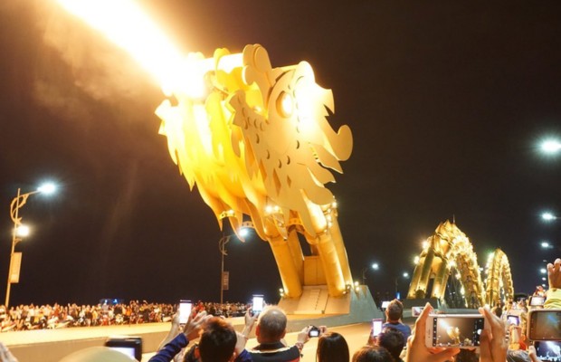 đầu rồng Cầu Rồng chiếu s&aacute;ng v&agrave;ng cam về đ&ecirc;m.