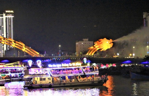 Du thuyền s&aacute;ng đ&egrave;n tr&ecirc;n s&ocirc;ng H&agrave;n với cầu d&acirc;y văng ph&iacute;a sau.