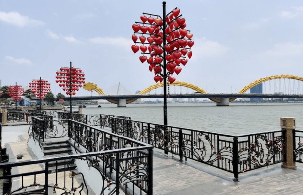 Cầu T&igrave;nh Y&ecirc;u Đ&agrave; Nẵng ban ng&agrave;y với đ&egrave;n tr&aacute;i tim v&agrave; nền Cầu Rồng.