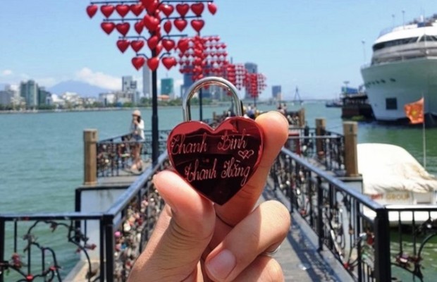 Du kh&aacute;ch cầm ổ kh&oacute;a t&igrave;nh y&ecirc;u khắc t&ecirc;n tại Cầu T&igrave;nh Y&ecirc;u Đ&agrave; Nẵng.