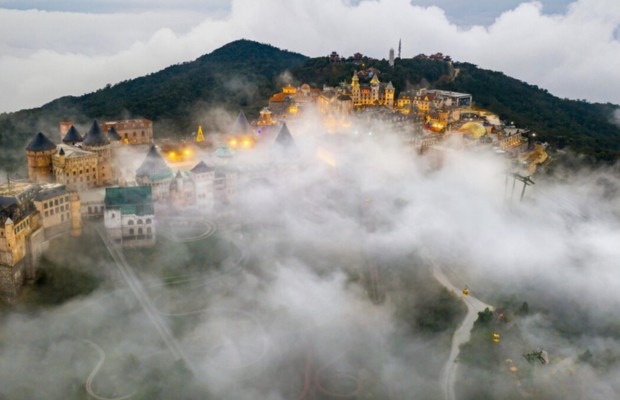 To&agrave;n cảnh L&agrave;ng Ph&aacute;p B&agrave; N&agrave; Hills từ tr&ecirc;n cao, bao phủ bởi lớp m&acirc;y sương d&agrave;y đặc m&ugrave;a mưa