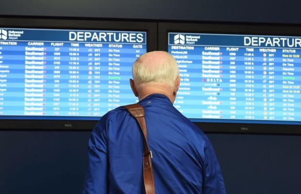 H&agrave;nh kh&aacute;ch theo d&otilde;i bảng th&ocirc;ng tin chuyến bay tại s&acirc;n bay qu&aacute; cảnh