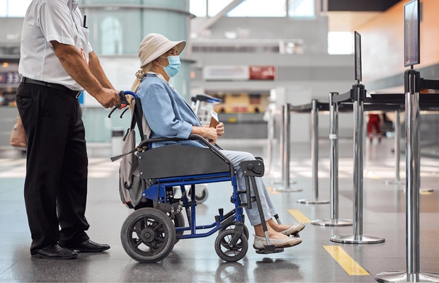 Nh&acirc;n vi&ecirc;n s&acirc;n bay đẩy xe lăn hỗ trợ h&agrave;nh kh&aacute;ch cao tuổi