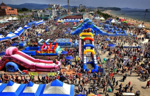 Du kh&aacute;ch trượt tr&ecirc;n m&aacute;ng trượt b&ugrave;n khổng lồ tại lễ hội Boryeong