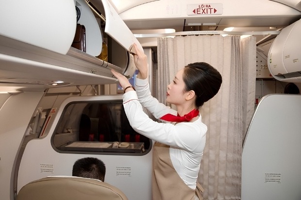 iếp vi&ecirc;n Sun PhuQuoc Airways kiểm tra ngăn h&agrave;nh l&yacute; x&aacute;ch tay ph&iacute;a tr&ecirc;n ghế ngồi