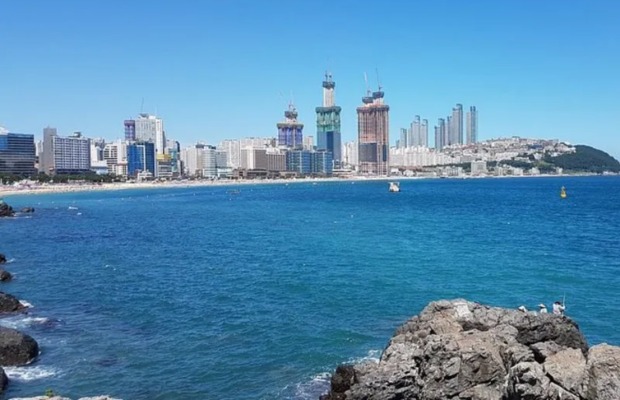 To&agrave;n cảnh b&atilde;i biển Haeundae nh&igrave;n từ tr&ecirc;n cao với b&atilde;i c&aacute;t d&agrave;i v&agrave; d&atilde;y nh&agrave; cao tầng hiện đại.