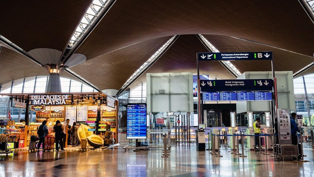 h&agrave;nh kh&aacute;ch l&agrave;m thủ tục check in tại quầy ga đi quốc tế của s&acirc;n bay quốc tế Kuala Lumpur
