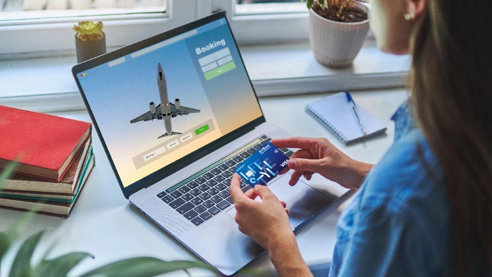 Người đang đặt v&eacute; m&aacute;y bay online (laptop/điện thoại) hoặc ảnh du kh&aacute;ch với vali tại s&acirc;n bay
